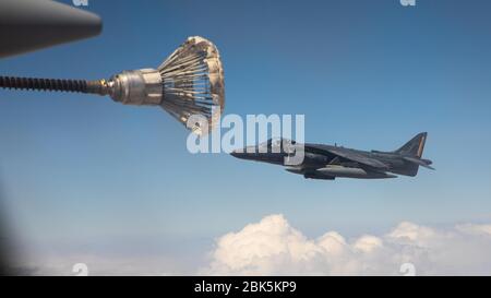 A U.S. Marine Corps AV/8B Harrier assigned to the 26th Marine Expeditionary Unit, conducts an aerial refuel from a KC-130J Super Hercules assigned to Marine Aerial Refueler Transport Squadron 352 (VMGR-352), Special Purpose Marine Air-Ground Task Force – Crisis Response – Central Command (SPMAGTF-CR-CC) 19.2, in the US Central Command area of responsibility, April 28, 2020. The SPMAGTF-CR-CC is a crisis response force, prepared to deploy a variety of capabilities across the region. (U.S. Marine Corps photo by Sgt. Branden J. Bourque) Stock Photo