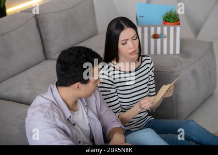 Young pretty woman reading a document and man. Stock Photo