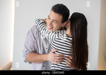 Young smiling dark-haired man hugging a woman. Stock Photo