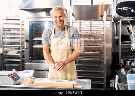 Professional chef working with dough in bakery Stock Photo