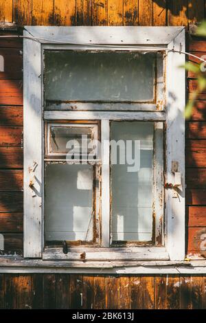 An old wooden white window in a country house. The paint was old and peeling Stock Photo