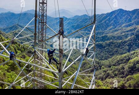 Hanzhong. 30th Apr, 2020. Aerial photo taken on April 30, 2020 shows electricians working at the construction site of an ultra-high voltage (UHV) direct-current (DC) transmission line in northwest China's Shaanxi Province. Nearly 10,000 electricians from across the country are building the Shaanxi section of the À800-kv UHV DC transmission line between northwest China's Qinghai Province and central China's Henan Province. Credit: Tao Ming/Xinhua/Alamy Live News Stock Photo