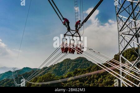 Hanzhong. 1st May, 2020. Aerial photo taken on May 1, 2020 shows electricians working at the construction site of an ultra-high voltage (UHV) direct-current (DC) transmission line in northwest China's Shaanxi Province. Nearly 10,000 electricians from across the country are building the Shaanxi section of the À800-kv UHV DC transmission line between northwest China's Qinghai Province and central China's Henan Province. Credit: Tao Ming/Xinhua/Alamy Live News Stock Photo