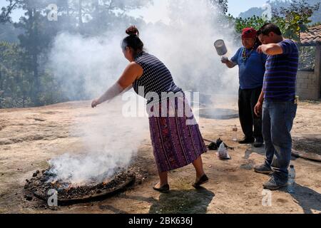 Shaman performing a Mayan healing ceremony for a family on the top of the Pascual Abaj hill, where the sacred stone is found. Some sources indicate th Stock Photo