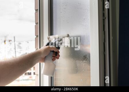 a man washes a window in an apartment. House cleaning Stock Photo