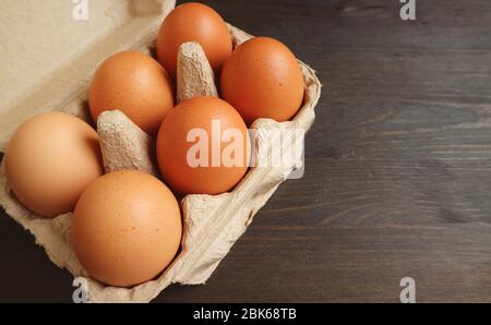 Paper Box of Organic Chicken Eggs Isolated on Wooden Table with Copy Space Stock Photo