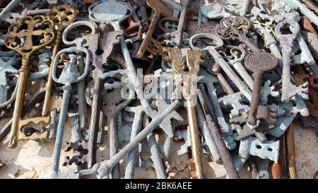 Different vintage keys made by metal casting from yellow, brown and gray metal. Antique ornate keys with whimsical sculptural handles. Mess heap of va Stock Photo