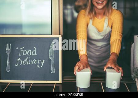 Young woman serving healthy take away food inside restaurant - Happy girl working inside delivery food ghost kitchen - Online business order service c Stock Photo