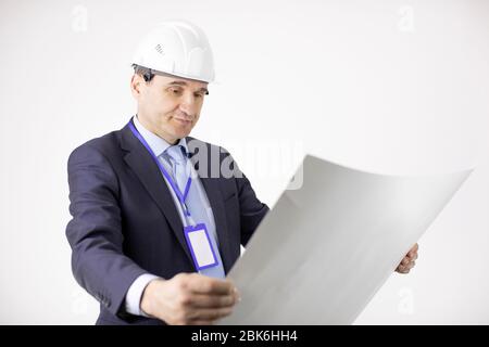 Satisfied cheif engineer in safety helmet working with blueprint documents Stock Photo