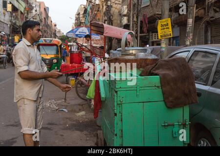 New Delhi, India - June 23, 2018: Man churning indian dessert dish streets of old delhi chandni chowk in Delhi India Stock Photo