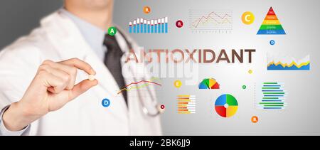 Nutritionist giving you a pill with ANTIOXIDANT  inscription, healthy lifestyle concept Stock Photo