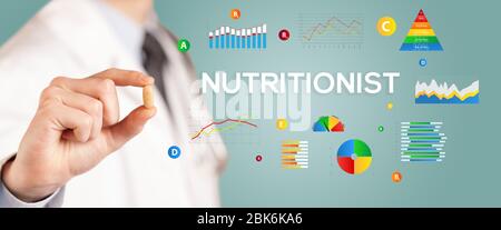 Nutritionist giving you a pill with NUTRITIONIST  inscription, healthy lifestyle concept Stock Photo
