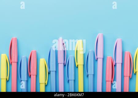 Multi-colored markers on a blue background with free space. Stock Photo