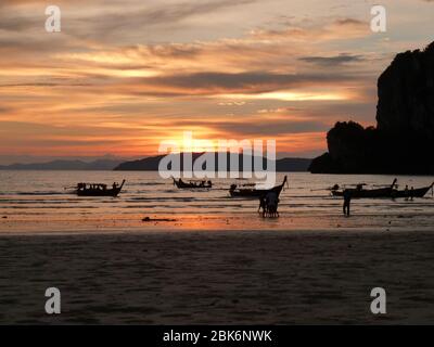 Traditional long-tail boat on the beach in Thailand at sunset Stock Photo