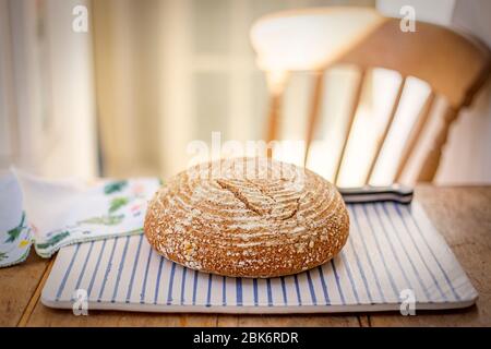 Home-made sourdough bread presented on a pottery plate (landscape format) Stock Photo