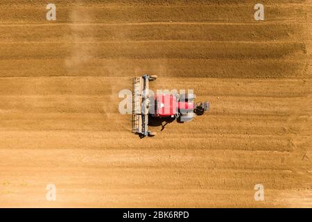 Pre seeding flattening roller Tractor working in a field, Aerial image. Stock Photo