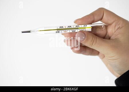 Glass thermometer in female hand which shows extremely high temperature above 40 Stock Photo