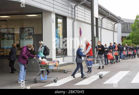People queuing outside a supermarket in  Munich, Bavaria, Germany Stock Photo