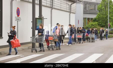 People queuing outside a supermarket in  Munich, Bavaria, Germany Stock Photo