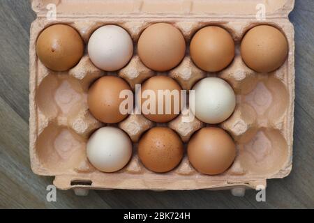 Cardboard carton containing various hens eggs and several empty spaces Stock Photo