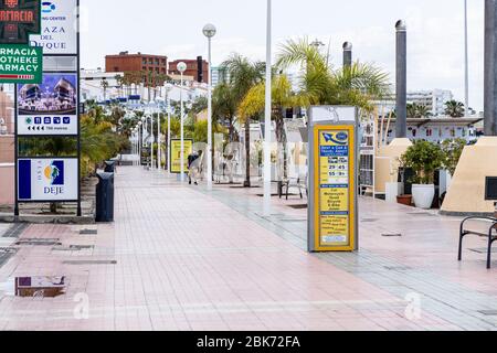 Solitary masked man walks on the promenade at Fanabe during the covid 19 lockdown in the tourist resort area of Costa Adeje, Tenerife, Canary Islands, Stock Photo