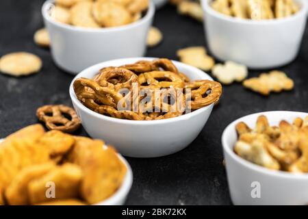 Portion of mixed Snacks on dark background (detailed close up shot; selective focus) Stock Photo