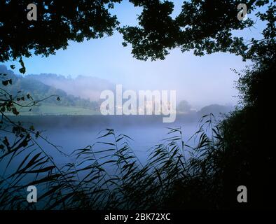 Tintern Abbey beside River Wye, Tintern Pava, Chepstow, Monmouthshire, South Wales. Misty summer morning. Stock Photo