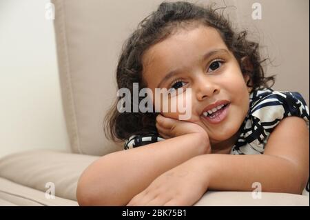 Pune, Maharashtra, India, Asia, Sept. 2015 - Indian Little cute Baby sitting on sofa and smiling Stock Photo