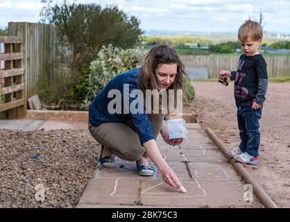 Camptoun, East Lothian, Scotland, United Kingdom. 2nd May, 2020. A community in lockdown: residents in a small rural community show what life in lockdown is like for them. Pictured: Toby, aged 2 years, learns how to play hopscotch with his mother, Lucy Stock Photo