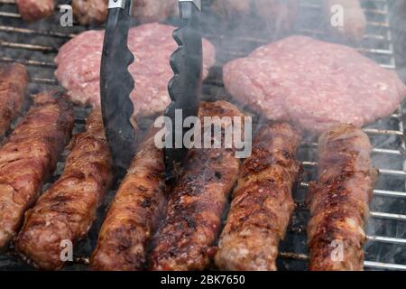 Chevapchichi and burgers grilled on barbecue, close up Stock Photo