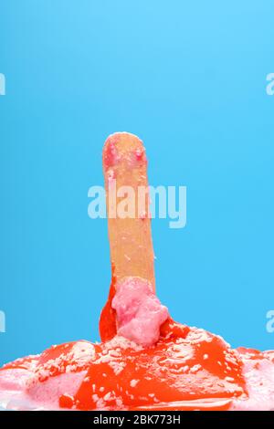 red popsicle with shredded coconut melted on a blue background Stock Photo