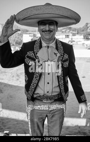 Portrait of a mexican cowboy dressed the traditional way saluting with a smile. Stock Photo