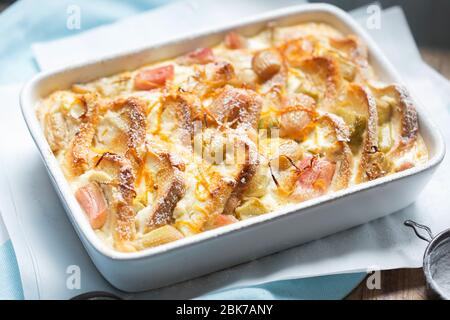 Rhubarb & ricotta bread & butter pudding with icing sugar Stock Photo