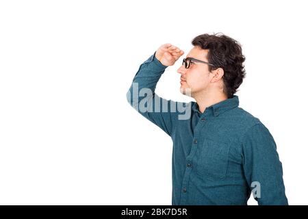 Confident businessman looking attentive far away ahead, holding hand to forehead over eyes, isolated over white background with copy space. Guy using Stock Photo