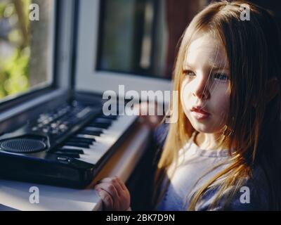 Little curly girl blowing dandelion Stock Photo