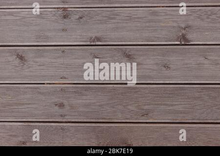 Old exterior wooden decking or flooring on the terrace.Background of a wenge-colored terrace Board with horizontal stripes. Design backgrounds Stock Photo