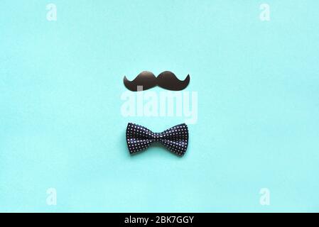 Father's Day or Hipster Concept flat lay. Creative composition with bowtie and moustache on blue background, copy space. Celebration concept, greeting Stock Photo