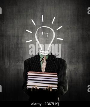 Ideas Bulb Holding Books And Wearing Suit,  While Standing Before A Chalkboard, Stock Photo