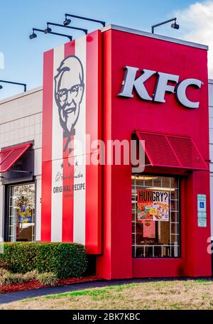 Charlotte, NC/USA - December 14, 2019: Medium vertical editorial shot of red and white blocked corner of 'KFC' retail fried chicken outlet showing bra Stock Photo