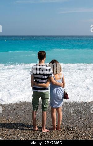 Rear view of a couple embracing in front of the Mediterranean sea in Nice, French Riviera, Cote D'Azur, France, Europe Stock Photo