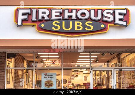 Charlotte, NC/USA - December 26, 2019: Facade of 'Firehouse Subs' sandwich shop showing brand/logo signage and lighted interior of restaurant. Stock Photo