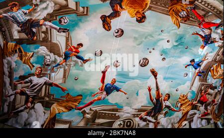 Marouflage (ceiling painting) with soccer scenes during the FIFA World Cup 2006 in Cologne Central Station. On an area of more than 800 square meters, Adidas has had a fresco installed on the ceiling of Cologne's main train station. In a true-to-the-original antique look, national players such as Michael Ballack, David Beckham, Zinédine Zidane and Juan Román Riquelme float high above the heads of passers-by Stock Photo