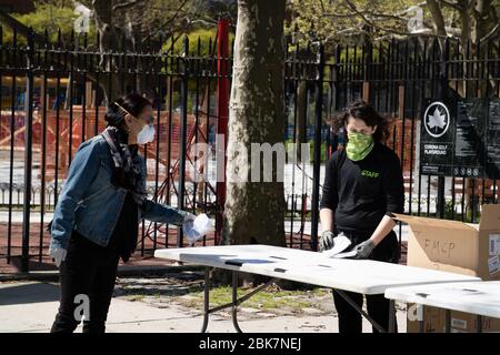 New York, United States. 02nd May, 2020. A woman receives free face masks distributed by the New York City government at Corona Golf Playground where the community has been hard hit by the coronavirus pandemic.USA has confirmed 1.14m cases, 142000 recovered and 65830 deaths to the corona virus. Credit: SOPA Images Limited/Alamy Live News Stock Photo