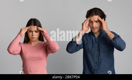 Asian young couple having headache cause of fight, touching their heads, panorama with copy space Stock Photo