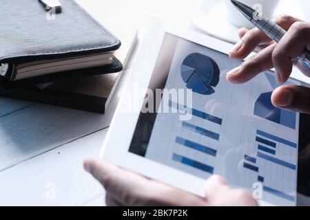 person hand analyzing financial data in digital tablet  Stock Photo