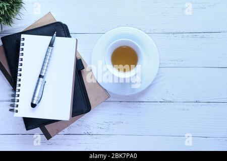 stack of notebooks and a tea cup on table Stock Photo