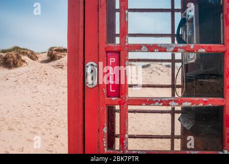 Door handle of an old British red telephone box on a sandy beach in Studland, near Sandbanks, Dorset, UK Stock Photo