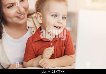 Online education of children quarantine, boy learns through video chat. Concept viewing cartoons or videoblog Stock Photo