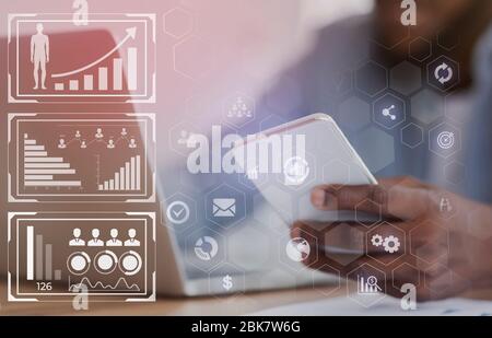 Unrecognizable black HR manager using smartphone and working on laptop Stock Photo