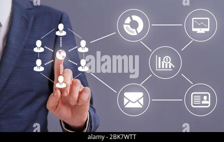 Businessman hand pressing globe icon on digital scheme Stock Photo